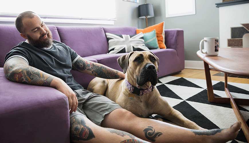 Man with Tattoos Sitting on Living Room Floor