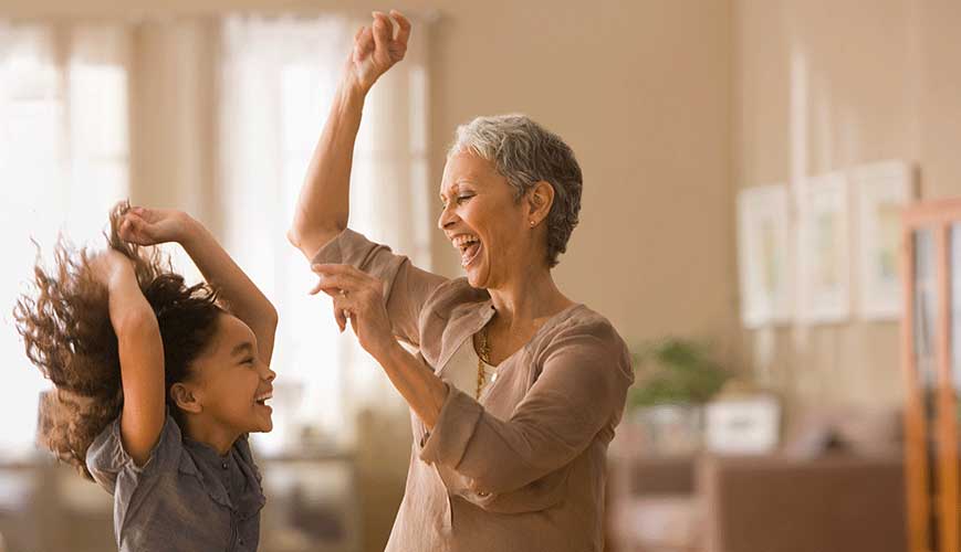 Grandma and grandchild dancing in Living Room